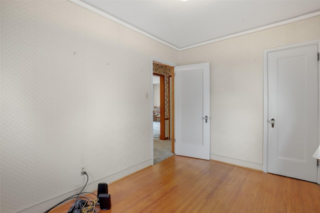 unfurnished bedroom featuring ornamental molding and light hardwood / wood-style floors