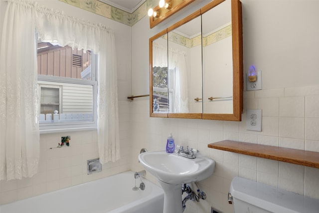 bathroom with a tub, sink, tile walls, toilet, and crown molding