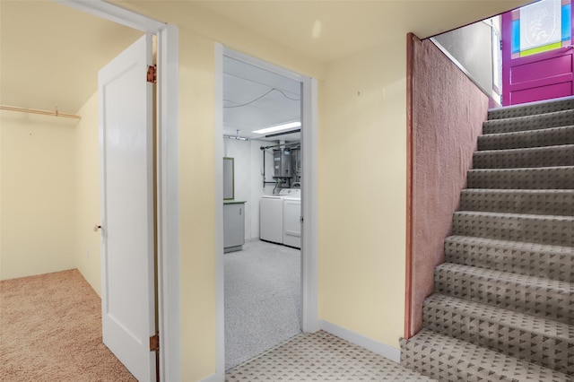 staircase with carpet floors and washing machine and dryer