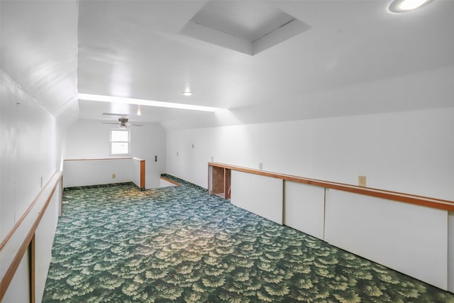 additional living space featuring lofted ceiling and dark carpet