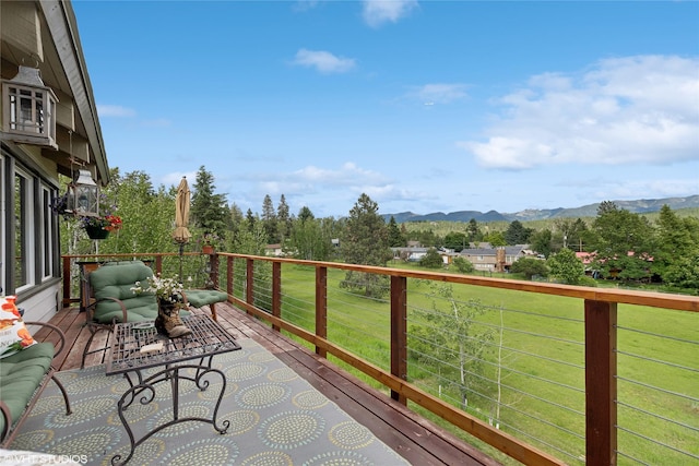 deck featuring a mountain view and a yard