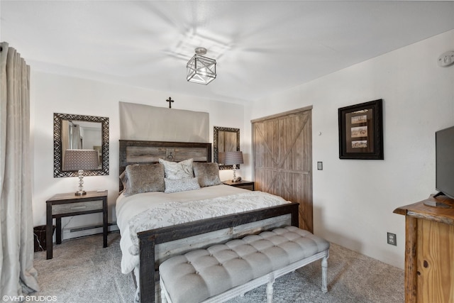 bedroom with carpet floors, a barn door, and baseboard heating