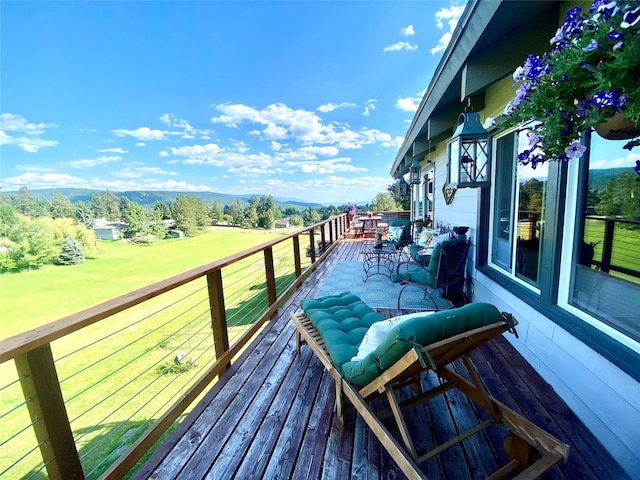 deck with a mountain view and a lawn