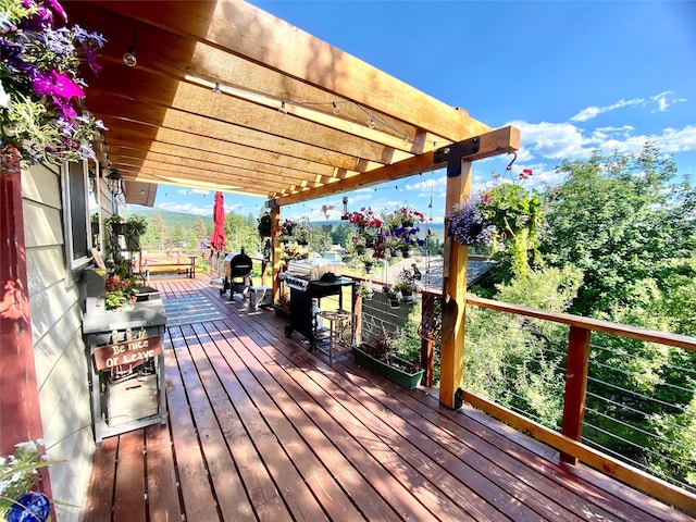 wooden deck with grilling area and a pergola