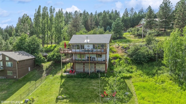 back of property featuring a wooden deck and a lawn