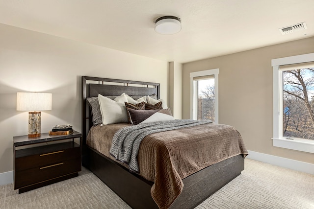 carpeted bedroom featuring multiple windows