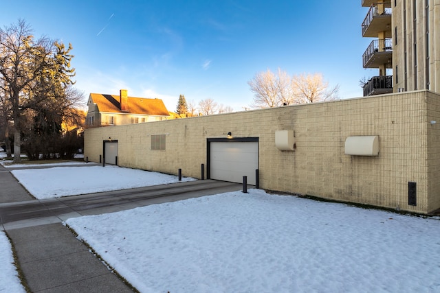 snow covered property with a garage