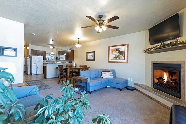 carpeted living room featuring ceiling fan and a textured ceiling