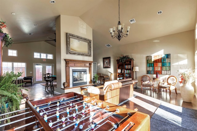 living room with an inviting chandelier, wood-type flooring, and high vaulted ceiling