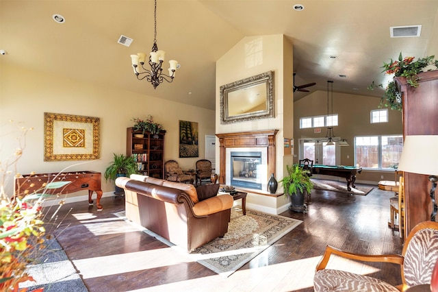 living room with an inviting chandelier, billiards, dark hardwood / wood-style floors, and high vaulted ceiling