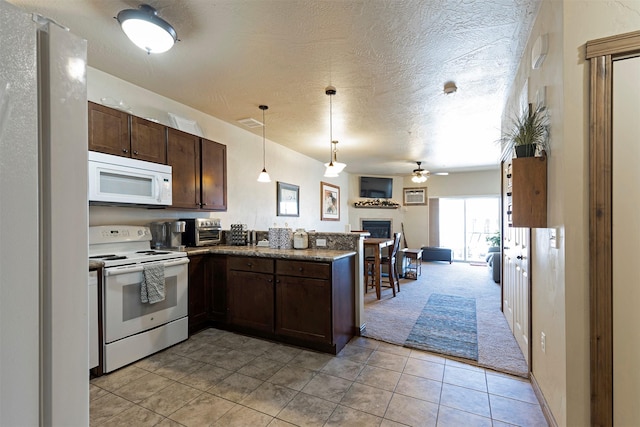 kitchen with dark brown cabinets, hanging light fixtures, a textured ceiling, kitchen peninsula, and white appliances