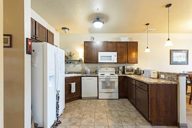 kitchen with decorative light fixtures, sink, light tile patterned floors, white appliances, and a textured ceiling