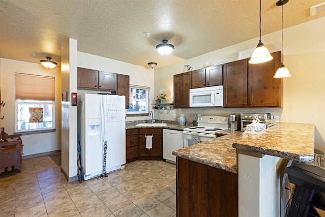 kitchen with a breakfast bar, sink, decorative light fixtures, kitchen peninsula, and white appliances