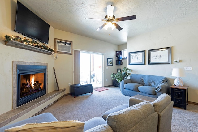 carpeted living room featuring ceiling fan, a textured ceiling, a tile fireplace, and an AC wall unit