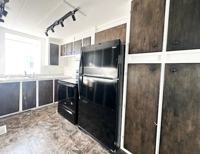 kitchen featuring sink, dark brown cabinetry, and black appliances