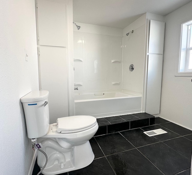 bathroom featuring  shower combination, tile patterned floors, and toilet