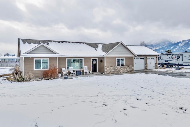 ranch-style house featuring a garage and a mountain view