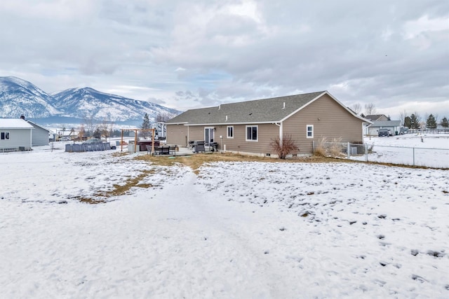 snow covered house featuring a mountain view