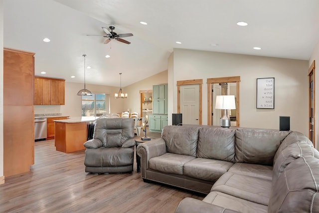 living room featuring lofted ceiling, ceiling fan with notable chandelier, and light wood-type flooring