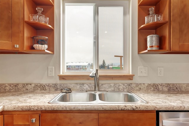 kitchen with sink, stainless steel dishwasher, and light stone counters