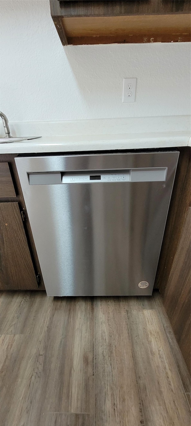 details featuring stainless steel dishwasher and light hardwood / wood-style floors