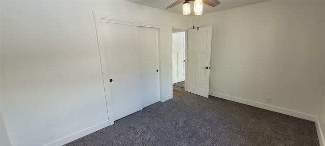 unfurnished bedroom featuring ceiling fan, dark carpet, and a closet