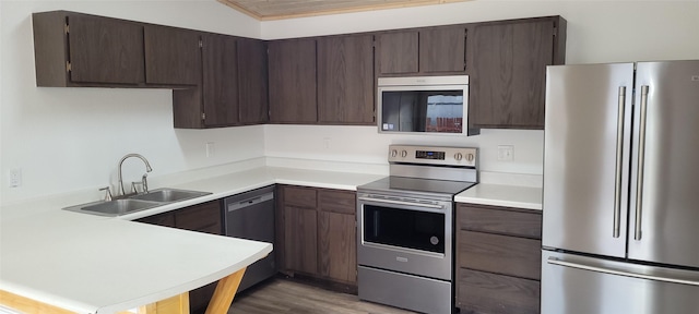 kitchen featuring stainless steel appliances, dark hardwood / wood-style floors, sink, and dark brown cabinets