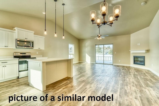 kitchen featuring white cabinetry, decorative light fixtures, light wood-type flooring, appliances with stainless steel finishes, and a kitchen island