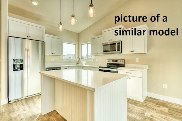 kitchen with hanging light fixtures, white cabinetry, appliances with stainless steel finishes, and a center island