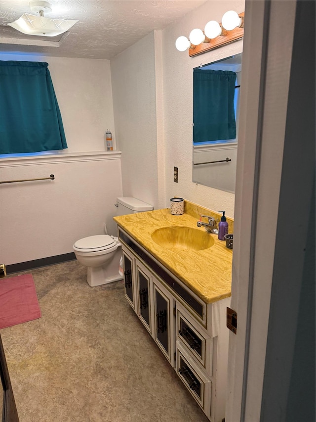 bathroom featuring vanity, toilet, and a textured ceiling