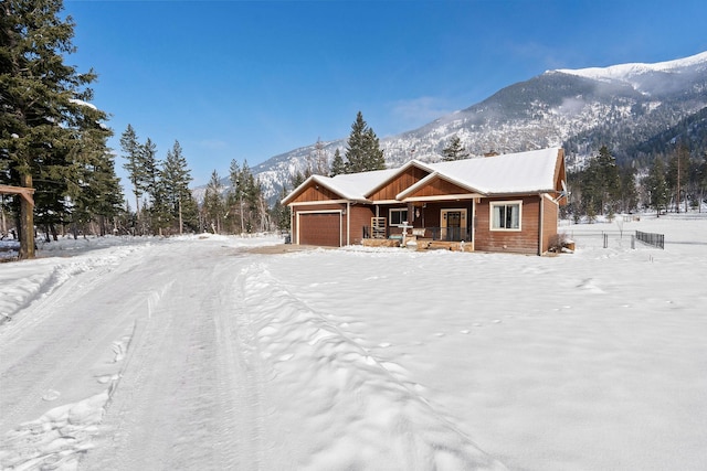 view of front of property with a garage, a mountain view, and a porch