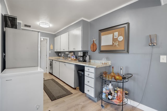 kitchen with sink, refrigerator, light hardwood / wood-style flooring, stainless steel dishwasher, and white cabinets