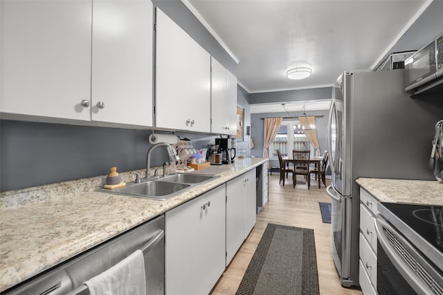 kitchen with white cabinetry, appliances with stainless steel finishes, sink, and light hardwood / wood-style floors