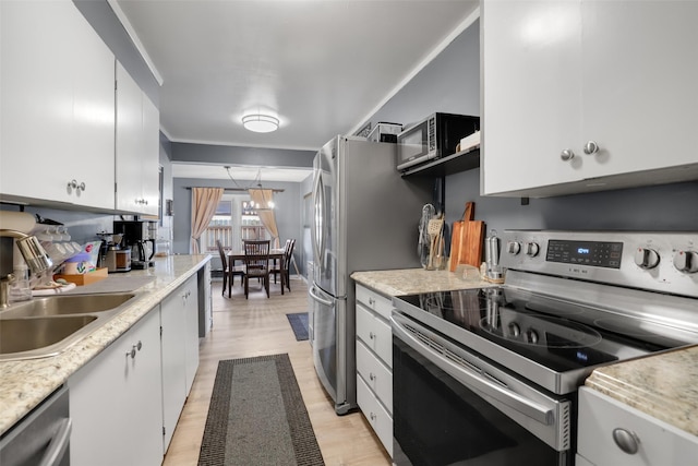 kitchen featuring stainless steel appliances, sink, light wood-type flooring, and white cabinets