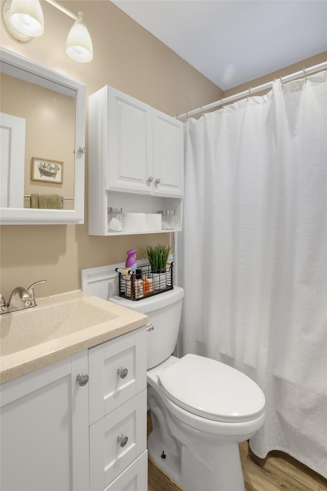 bathroom featuring vanity, hardwood / wood-style floors, and toilet