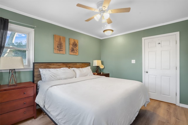 bedroom with ornamental molding, ceiling fan, and light wood-type flooring