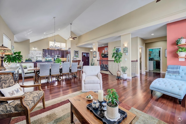 living room featuring dark wood-type flooring, high vaulted ceiling, and a notable chandelier