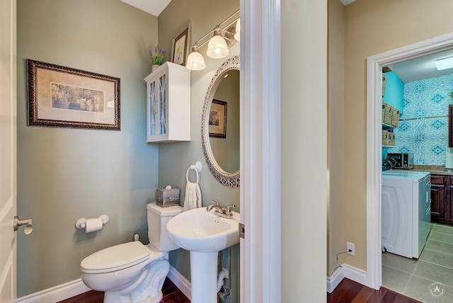 bathroom with toilet, washer / dryer, and hardwood / wood-style floors