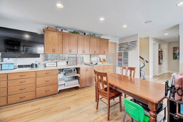 kitchen with tasteful backsplash and light wood-type flooring