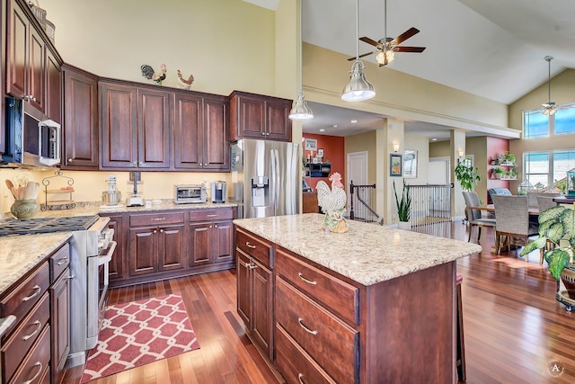 kitchen featuring stainless steel appliances, a kitchen island, dark hardwood / wood-style floors, and pendant lighting