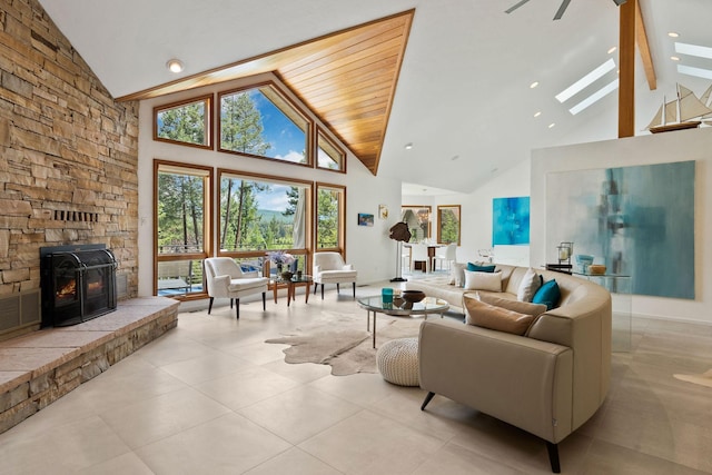 living room with a skylight, high vaulted ceiling, beamed ceiling, and light tile patterned flooring