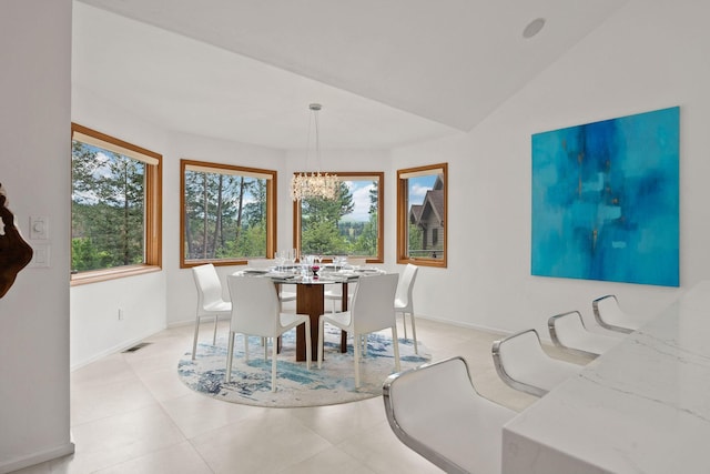 tiled dining room featuring an inviting chandelier and vaulted ceiling