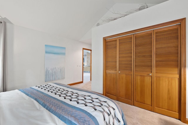 carpeted bedroom featuring vaulted ceiling and a closet