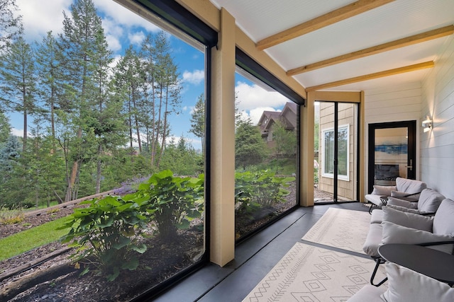 sunroom / solarium featuring a wealth of natural light and beamed ceiling