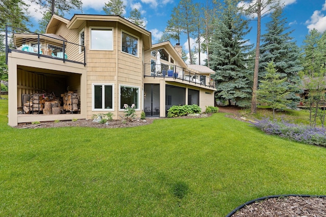 rear view of property with a lawn and a balcony