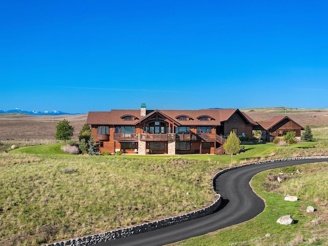 view of front of house with a mountain view and a front lawn