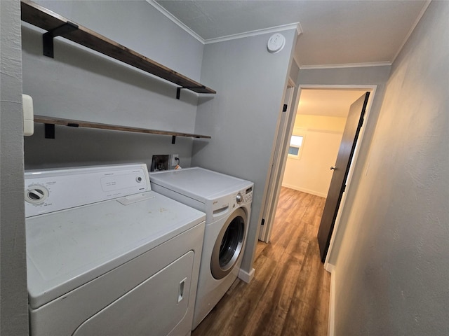 laundry area featuring ornamental molding, dark hardwood / wood-style floors, and washing machine and clothes dryer