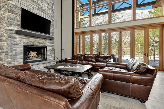 tiled living room with a towering ceiling and a fireplace