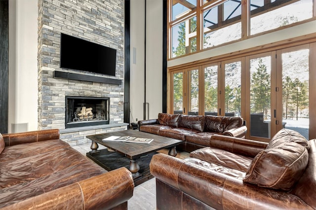 living room with a fireplace and a high ceiling