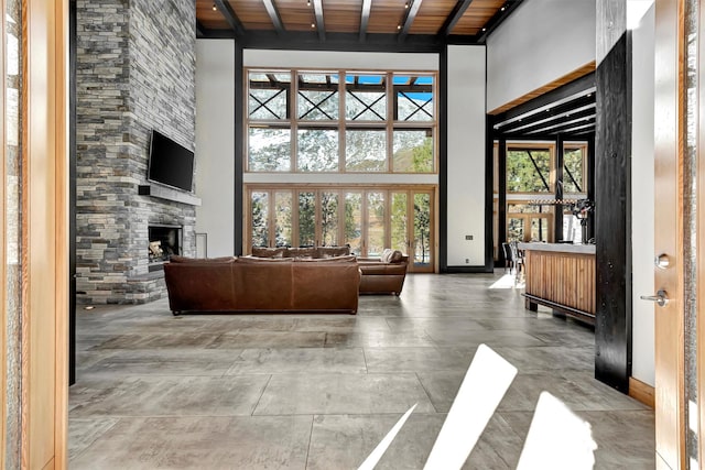 1180 Reardon Ln, Alberton, MT 59820 - living area with wood ceiling, a high ceiling, a fireplace, baseboards, and beamed ceiling